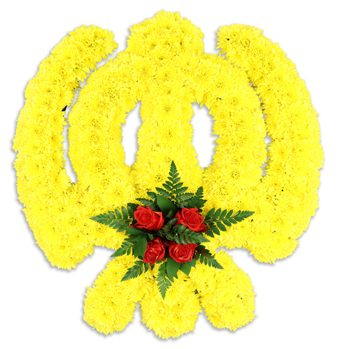 A bold, reverent floral Khanda sits centered on a stark white field, its entire structure masterfully formed from dense clusters of bright yellow chrysanthemums that create a textured, almost plush relief across the emblem's circular chakkar, the central double-edged sword and the outward-sweeping kirpans. The chrysanthemums' tiny petals knit together to follow each sweep and curve of the symbol, catching light on their soft ridges and lending the piece a warm, golden radiance. At the meeting point of the emblem's arms, an intimate cluster of deep red roses - tightly grouped and unmistakable against the yellow - becomes the visual and emotional core; those roses are surrounded and supported by dark green fern fronds whose lacy leaves deepen the contrast and introduce a cool, dignified frame. A subtle grey shadow beneath the arrangement suggests a freestanding memorial board or funeral wreath, prepared to be placed in a gurdwara or beside a commemorative display. The aroma is a gentle layering of fresh chrysanthemum and classic rose, and the textures invite both a visual and imagined tactile response: the chrysanthemums' cushiony mass versus the roses' velvety depth and the ferns' crisp fineness. Crafted with a sensitivity to Sikh symbolism and community tradition, this tribute reflects the kind of thoughtful work requested for memorial services and cultural observances across Woodside and neighbouring streets, where local families often choose floral emblems that honour heritage while speaking quietly of solace, respect and communal memory.