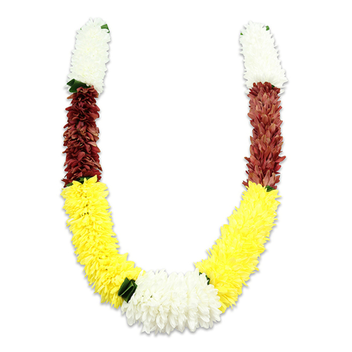 Photographed on a plain white field, this U-shaped ceremonial garland is a study in colour-blocked craftsmanship, composed of thousands of small fabric petals shaped into dense, tactile forms. From each top end a cylindrical segment of creamy white petals provides a luminous, serene beginning - delicate, fluffy and reminiscent of chrysanthemum or jasmine clusters often used in ritual adornment. That white band is followed by a compact section of deep maroon or reddish-brown, its richer tone creating a solemn contrast and lending the garland a grounded middle register. The dominant visual sweep is a prolonged band of vivid yellow, made up of plush, marigold-like blossoms that form the lower curve of the U with a generous, buoyant volume. At the lowest central junction, a broader bouquet of pure white, chrysanthemum-like flowers unites the two arms, producing a bright focal knot that balances the composition. Small, dark green leaf-like accents are inserted as subtle separators between colour fields, particularly between yellow and white at the base, offering a crisp, natural punctuation to the synthetic blooms. The fabric petals capture light with soft highlights and cushioning shadows, emphasizing the handmade assembly of individual blossoms into an ornate mala. Traditionally used for Hindu puja, temple offerings, weddings and festivals such as Diwali and Holi, the white-yellow-maroon palette symbolises purity, prosperity and devotion. Locally in Woodside - whether at community halls or family ceremonies - this durable, artist-made garland would serve as a durable, respectful emblem of celebration and reverence, its tactile density designed to withstand repeated ceremonial handling.